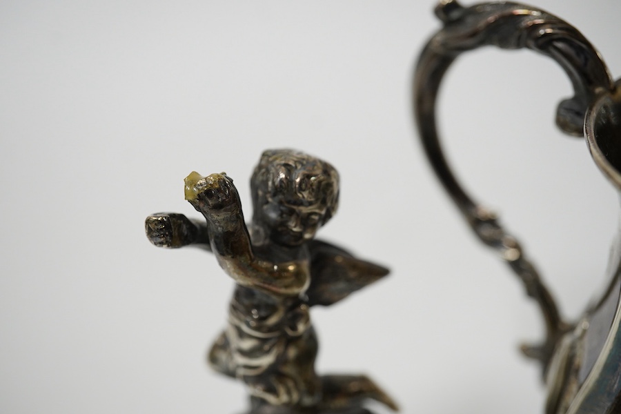 A small Victorian silver christening mug with embossed decoration and scroll handle, Hilliard & Thomason, Birmingham, 1860, 82mm and a pair of cast silver cherub figures holding fan, (Chester import marks) on triangular